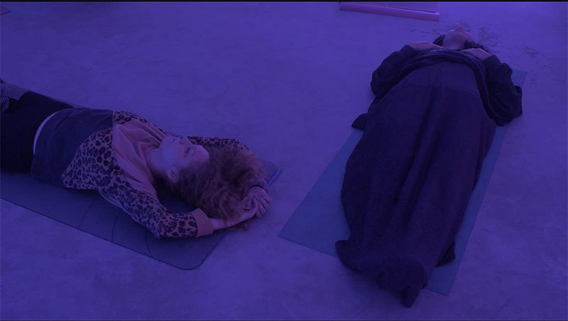 corps allongé et détendu sur des tapis yoga dans lumière englobante bleue