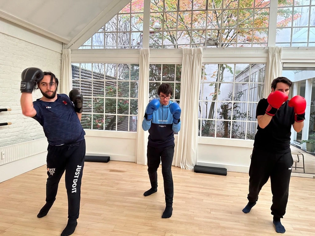 3 jeunes qui font de la boxe dans une salle aéré